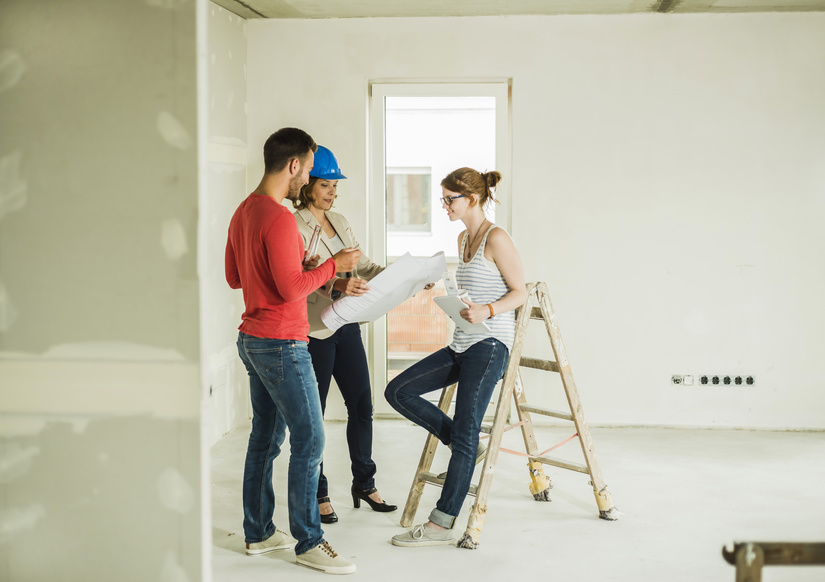 appartement - architecte montrant un plan à un jeune couple 