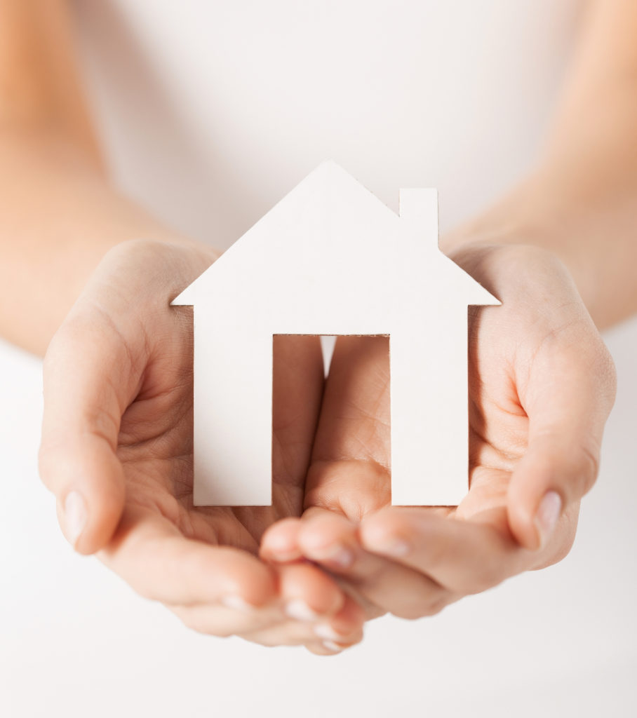 closeup pisture of woman hands holding paper house