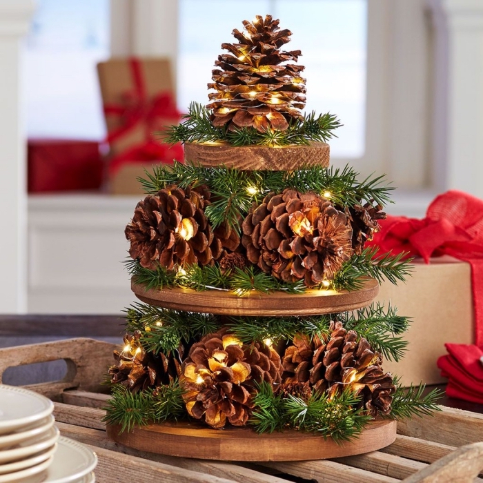 This image has an empty alt attribute; its file name is sapin-en-pomme-de-pin-diy-création-noel-à-faire-soi-même-pommes-de-pin-branches-guirlande-lumineuse-plateaux-en-bois.jpg