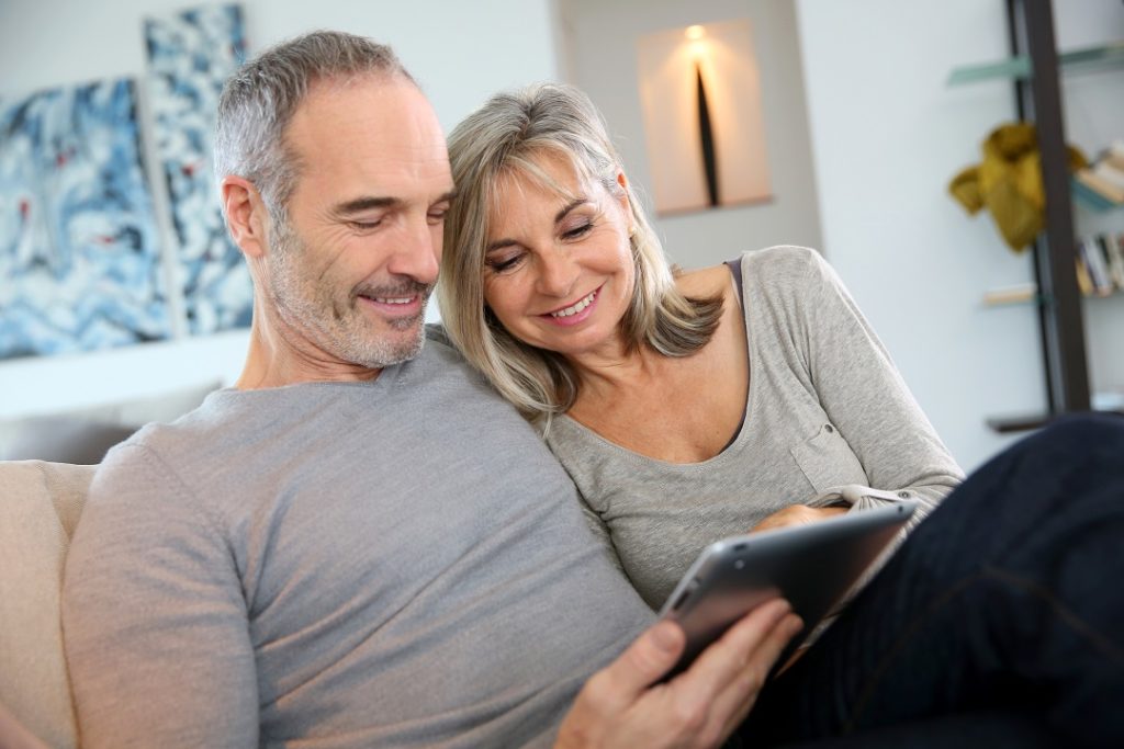 Mature couple at home websurfing with tablet